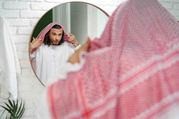 istock Young man getting ready and looking at the mirror in the bathroom 1850081852