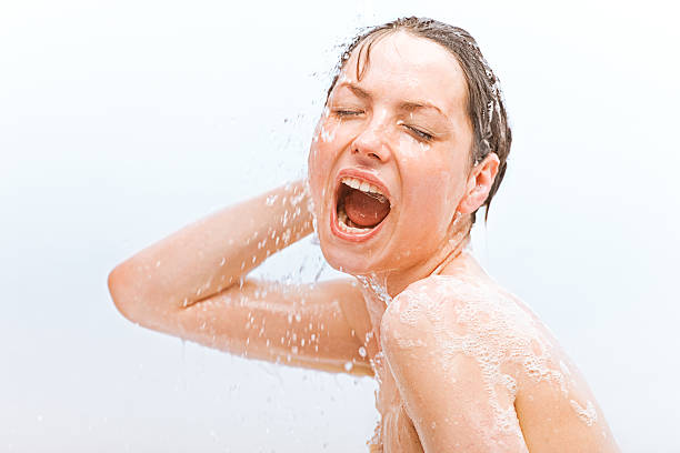 young woman having a shower head and shoulders portrait of young woman having a shower shower women falling water human face stock pictures, royalty-free photos & images