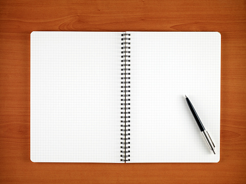 Directly above view of a blank notebook with a pen on it