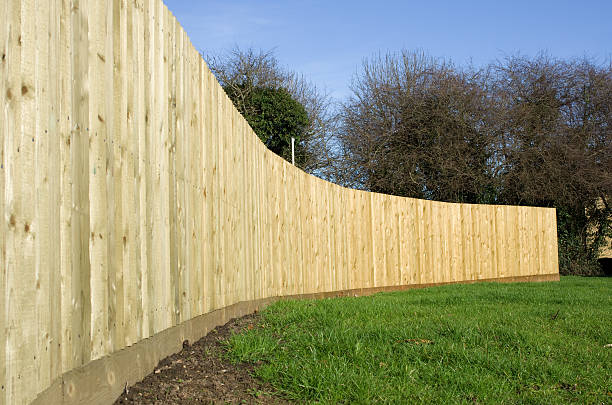 Long curving close boarded wooden fence stock photo