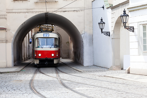Old Czech tram leaves the arch in a building in Prague. There is one place  in Prague where the trams are forced to give way to each other, since the width of the road is not letting you accomplish them disperse.