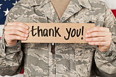 Soldier holding a thank you sign to his chest