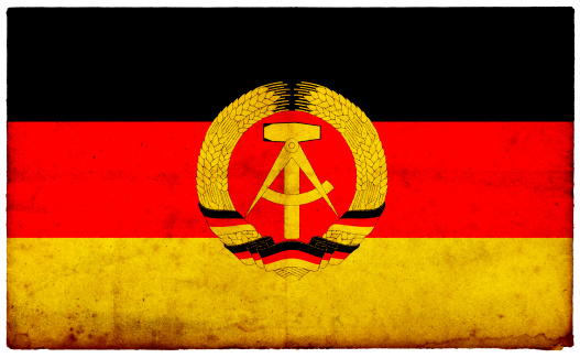 Grunge Former East German Flag on rough edged old postcard
