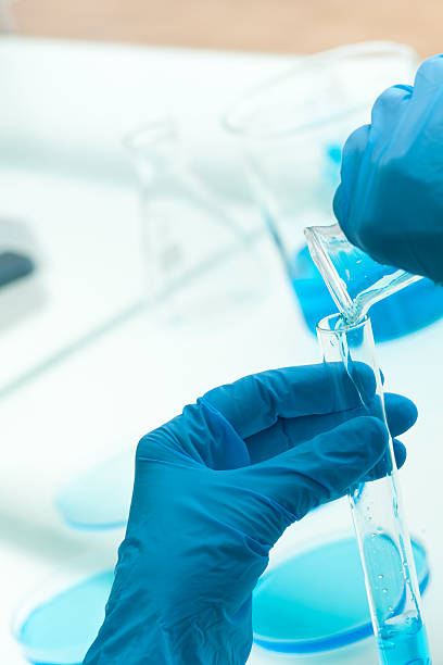chimico versare blu liquido nella provetta - test tube biologist laboratory beaker foto e immagini stock