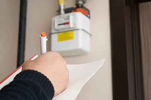 Photo of Close-up of worker reading and noting gas mater figure