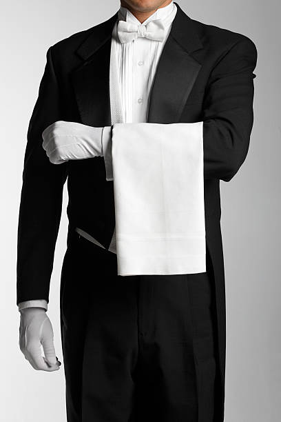 Butler or waiter wearing a white towel on his arm A butler at attention with a towel draped over his arm. Clipping path around the butler. formal glove stock pictures, royalty-free photos & images