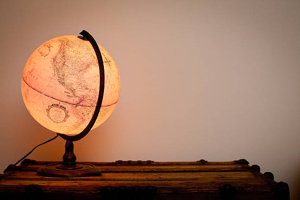 istock Lighted Globe Sitting on Vintage Wood Trunk 185010752