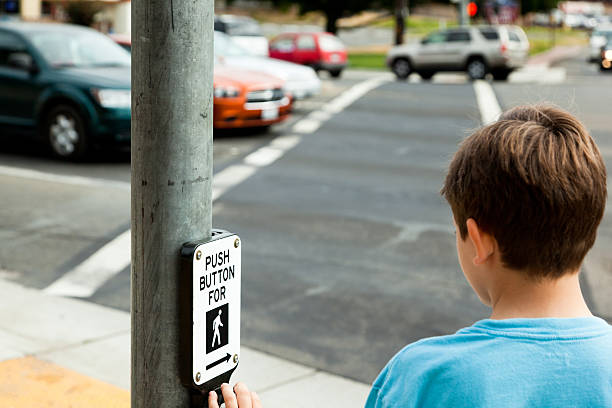 Child at Pedestrian Crossing Young child waiting to cross the street. mm1 stock pictures, royalty-free photos & images