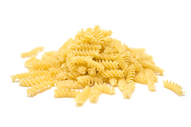 Fusilli, Fusilli Heap of raw Italian pasta isolated on a white background. fusilli stock pictures, royalty-free photos & images