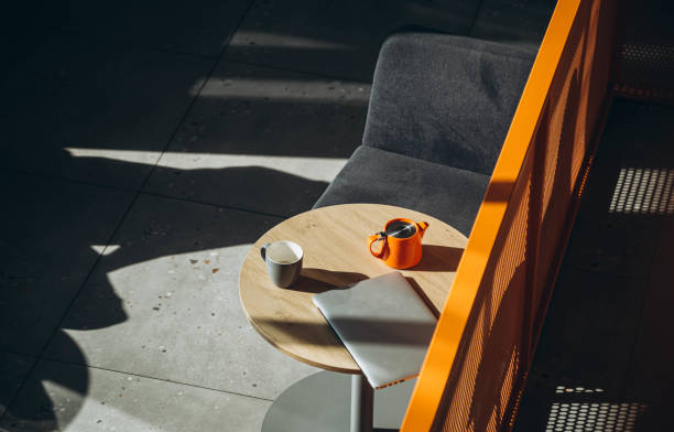 istock A laptop and a cup of tea on a table in a cafe interior with hard shadows. 1850138421