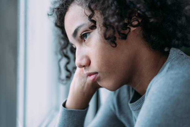 istock Pensive teenager looking through the window. 1850139496