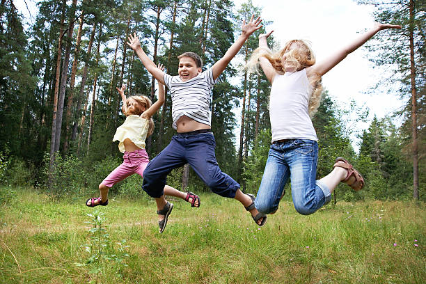 istock Children jump on lawn in summer forest 185014670