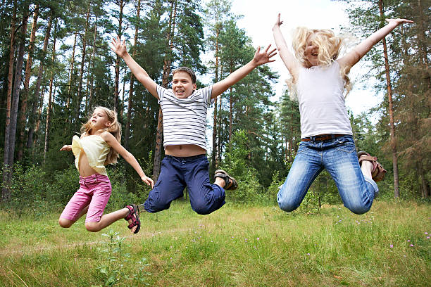 istock Children jump on lawn in summer forest 185014676