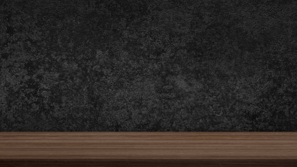 istock empty walnut wooden table top in foreground with dark black grunge stucco concrete at background. counter bar foreground can be used for display or montage products in luxury rustic mood. 1850159564