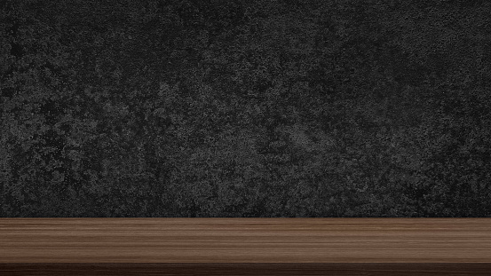 empty walnut wooden table top in foreground with dark black grunge stucco concrete at background. counter bar foreground can be used for display or montage products in luxury rustic mood.