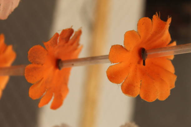 Selective focus shot of artificial flowers connected on a straw