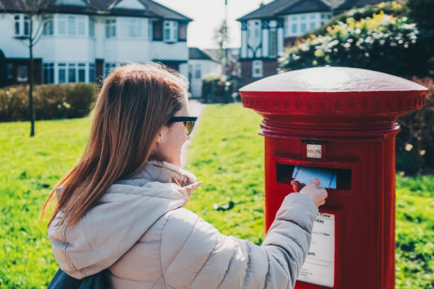 istock Woman in London posting letters in the mailbox 1850211035
