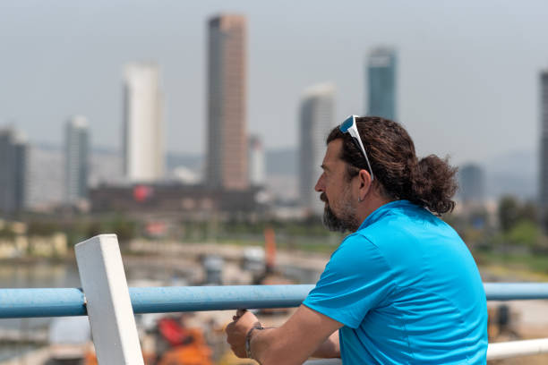 istock long-haired bearded man in his 50s watching the city 1850213253