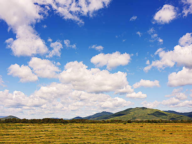 Landscape with mountain views, arable land, blue sky and beautif Landscape with mountain views, arable land, blue sky and beautiful clouds. Real scene without any light effects. stratosphere meteorology climate air stock pictures, royalty-free photos & images