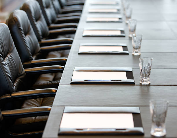 il tavolo della sala riunioni è impostato per una riunione - boardroom chairs foto e immagini stock