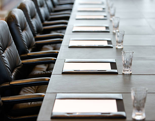 The boardroom table is set for a meeting The boardroom table is set for the Annual General Meeting conference table stock pictures, royalty-free photos & images