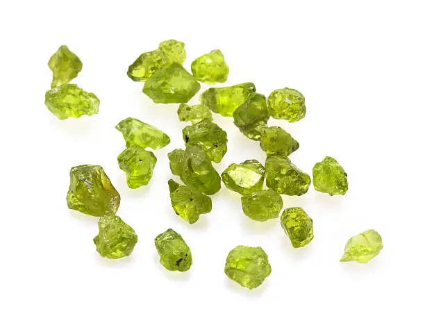 Closeup picture of many natural light green peridot gemstones isolated on white background.