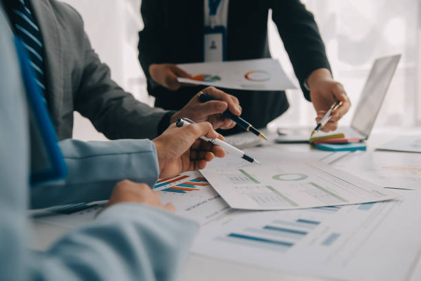 istock Financial analysts analyze business financial reports on a digital tablet planning investment project during a discussion at a meeting of corporate showing the results of their successful teamwork. 1850276600