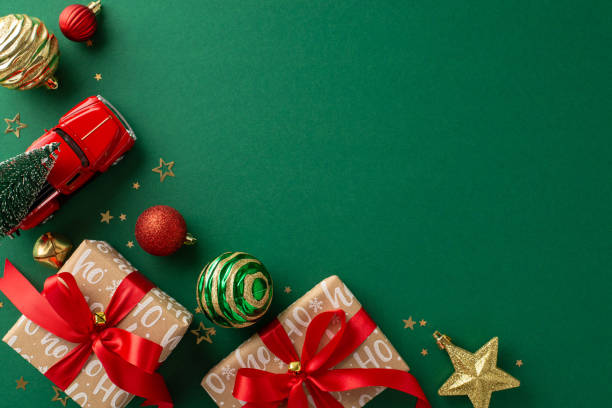 istock Enveloped in New Year magnificence. Above top view capturing trendy handmade gift boxes, baubles, merry ornaments, car toy transporting Christmas tree, confetti on green backdrop, with area for promo 1850290138