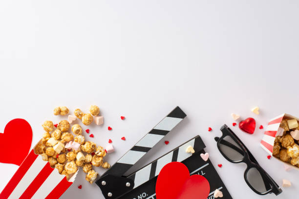 istock Love in every frame on Valentine's: top view clapperboard, 3D glasses, popcorn, heart decor, candy, marshmallow, and sprinkles on a lovely white background. Capture the essence of romance 1850292245