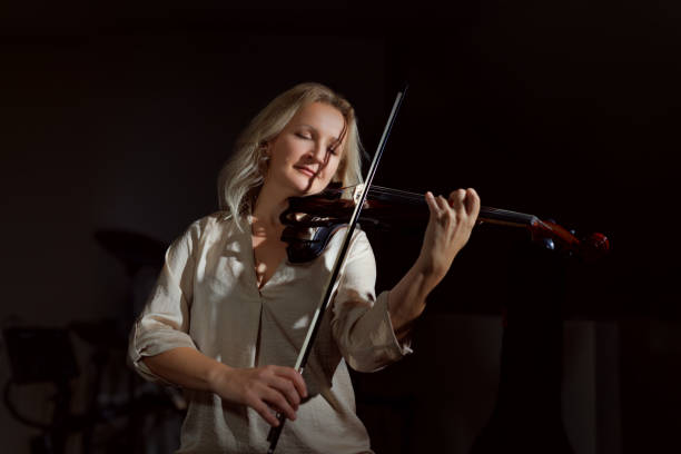 istock Blond-haired artist woman playing violin 1850292797