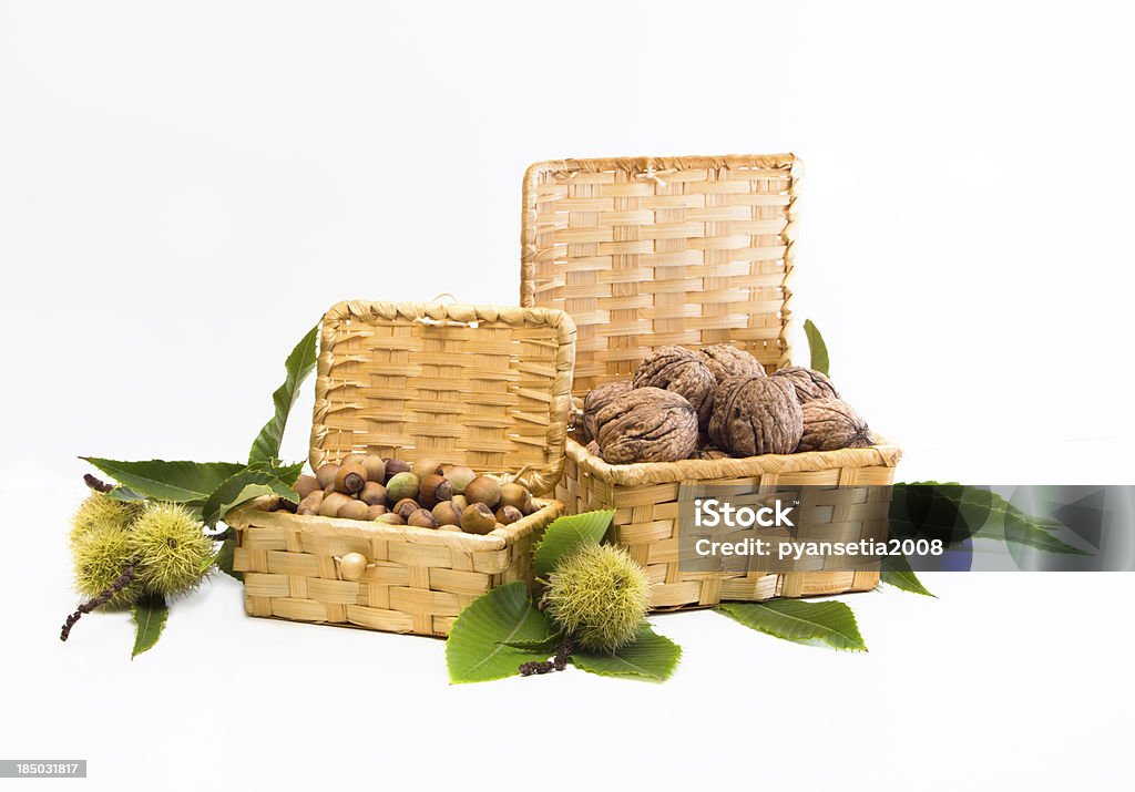Walnuts and hazelnuts in a wicker basket Walnuts and hazelnuts in a wicker basket on a white background Autumn Stock Photo
