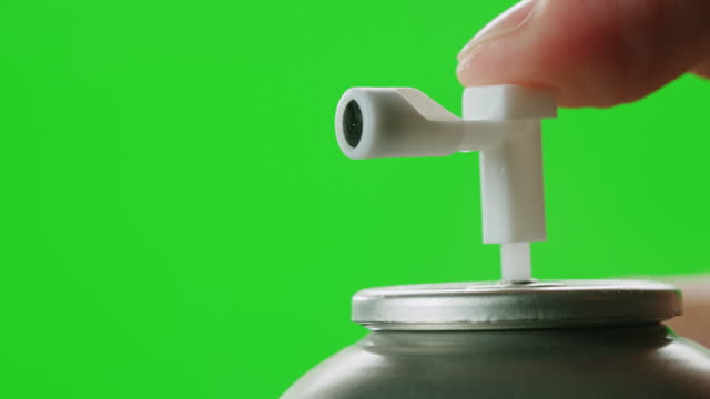 Man applying air freshener deodorant spray for bathroom, chroma key green screen closeup