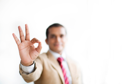 Businessman showing ok hand sign for perfection.