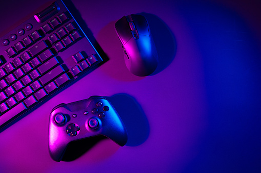 Computer keyboard, mouse and joystick on black background close up