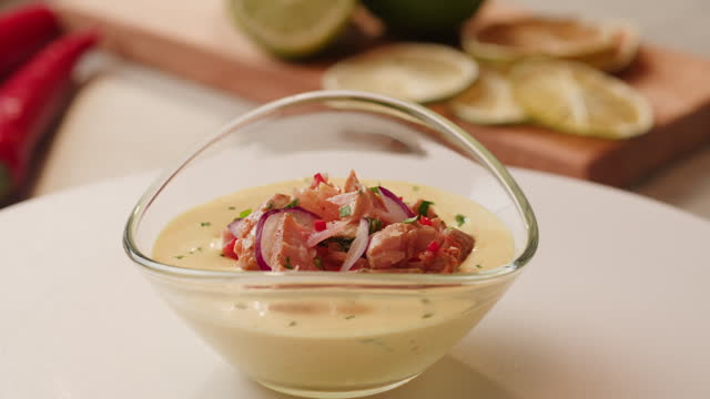 Chef cooking ceviche, leche de Tigre, traditional peruvian food, ceviche on table close-up. Traditional Peruvian or mexican cuisine with fresh seafood prawns in wine glass.