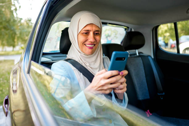 istock Muslim woman using phone while sitting in a car 1850367538