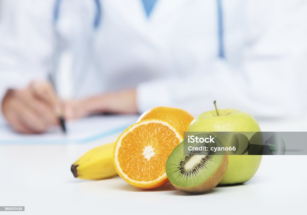 Stick to your diet by preparing healthy fresh fruit for work Nutritionist Doctor is writing a prescription. Focus on fruit Alternative Medicine Stock Photo