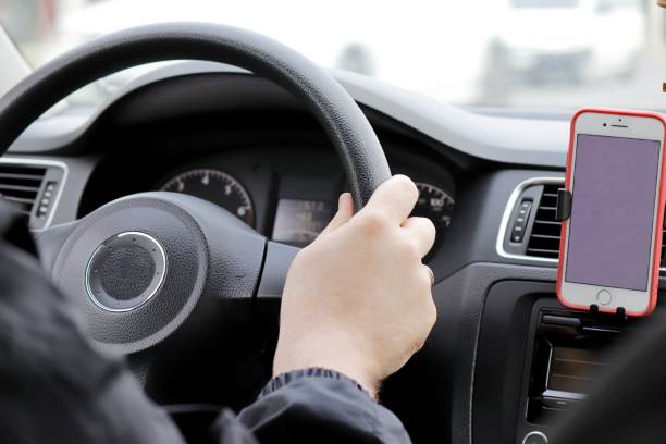 istock View inside the car, hands on the steering wheel, smartphone screen on the dashboard 1850398188