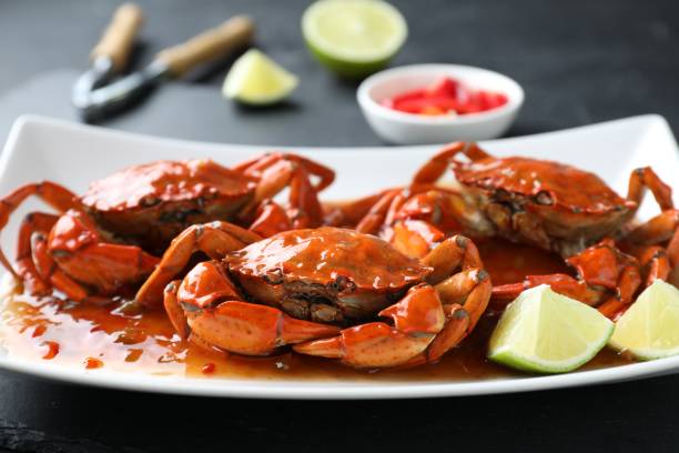istock Delicious boiled crabs with sauce and lime on black table, closeup 1850418391