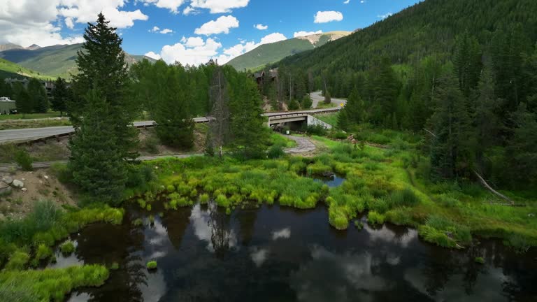 Pond lake mirror reflection clouds aerial cinematic drone Keystone Blue River ski resort summer Breckenridge Colorado Vail resort Epic Pass ski snowboard bike biking biker path slowly forward motion