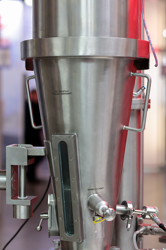 Close up of fluid bed spray granulator and dryer in pharmaceutical factory. Selective focus.