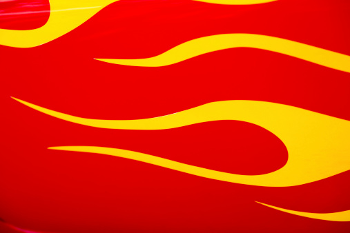 A close up of red and yellow hot rod flame paint job on a classic car.