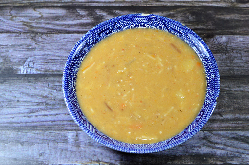 Lentil soup, a soup with lentils as its main ingredient, may include vegetables such as carrots, potatoes, celery, parsley, tomato, pumpkin, ripe plantain, vermicelli and onion, selective focus