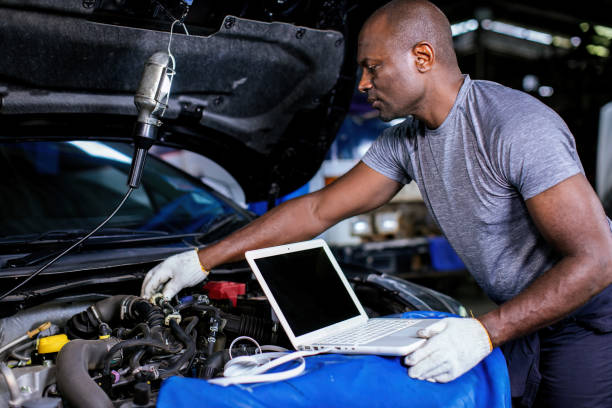 istock Mechanic using compute for Diagnostic  machine tools ready to be used with car. Car mechanic using a computer laptop to diagnosing and check up on car engines parts for fixing and repair 1850516914