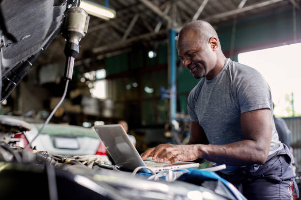 istock Mechanic using compute for Diagnostic  machine tools ready to be used with car. Car mechanic using a computer laptop to diagnosing and check up on car engines parts for fixing and repair 1850516917