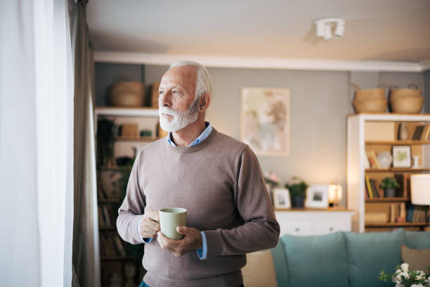 istock Senior man looking out of window at home 1850543748
