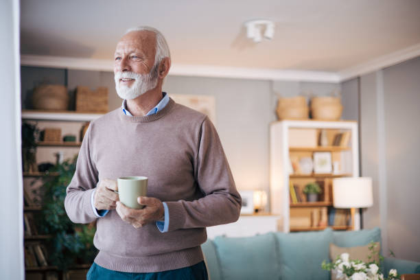 istock Senior man looking out of window at home 1850543750