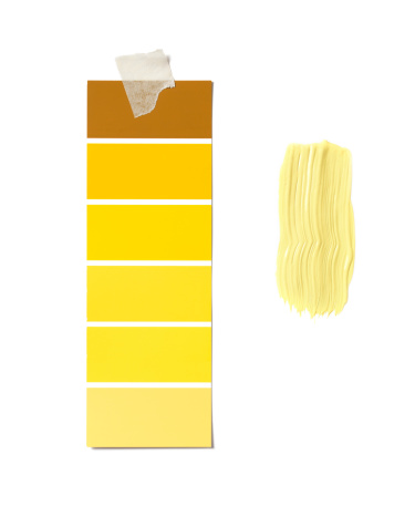 Paint swatch with yellow paint on white wall