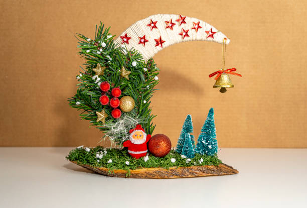 Clove-studded orange tied with red ribbon suspended against white background, evoking festive and aromatic ambiance.
