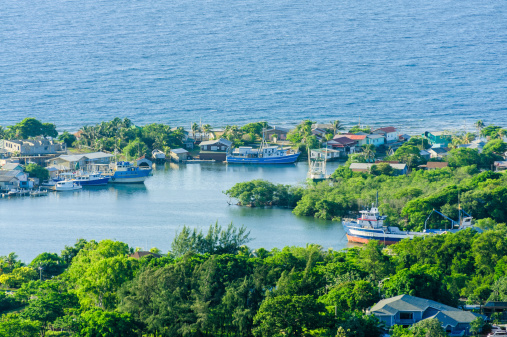 French Harbor Roatan.  Pirate cove inlet with boats and houses.  Captured as a 14-bit Raw file. Edited in 16-bit ProPhoto RGB color space.
